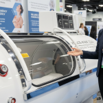 La persona que explica la cámara de oxígeno hiperbárico