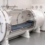 white hard-shell hyperbaric chamber with technician in clinic