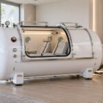 white hard-shell hyperbaric chamber with seats and compressor unit
